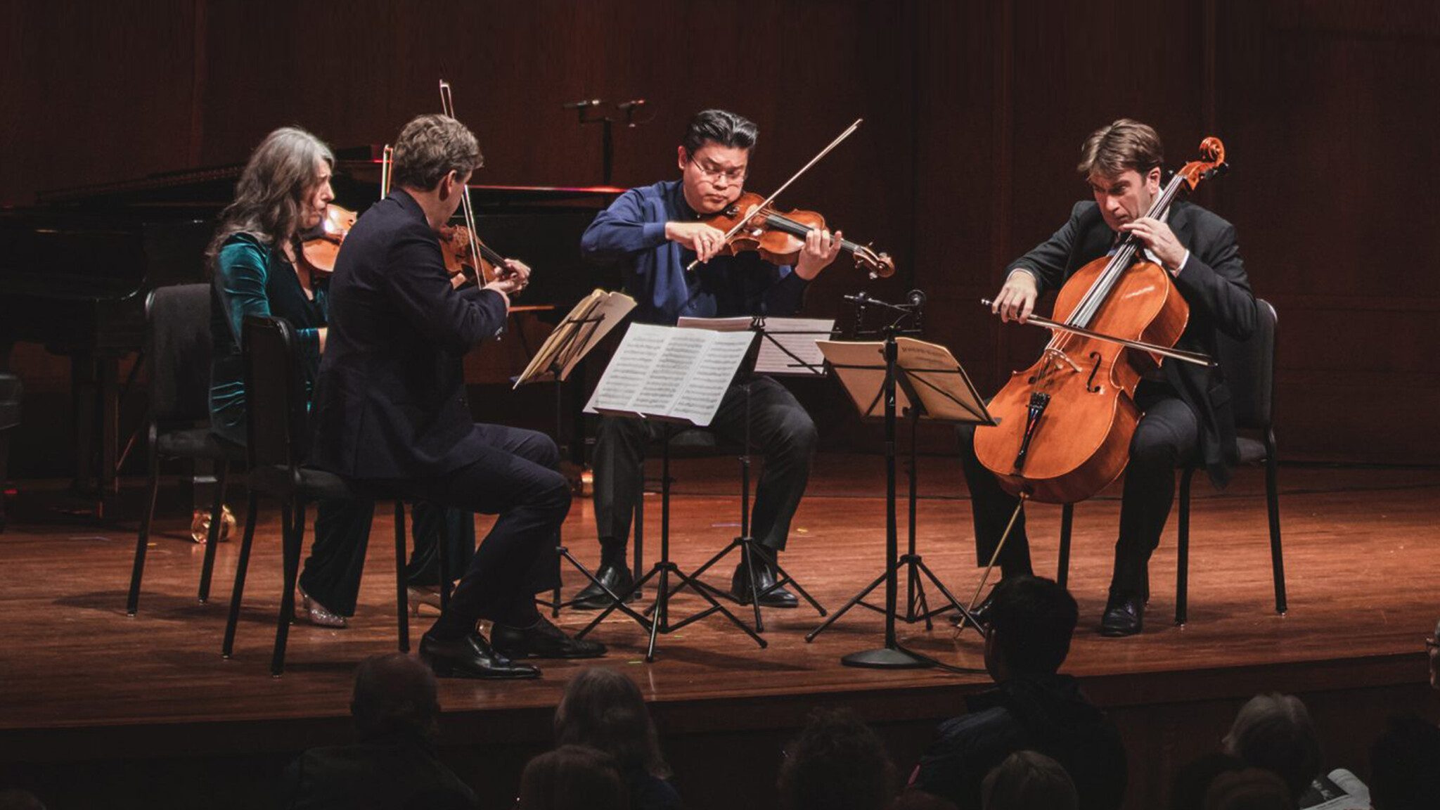 Classical musicians performing in a string quartet on stage during the Seattle art scene's spring showcase.