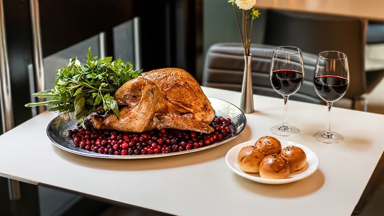 A roasted turkey on cranberries with herbs, paired with two glasses of red wine and a plate of rolls, makes for a perfect feast. Whether you're indulging at home or exploring Seattle restaurants, don't let the Procrastigobbler in you delay this festive dining experience.