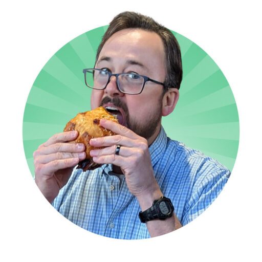 A person with glasses is eating a large sandwich while wearing a blue checkered shirt and a wristwatch, set against a green radial background.
