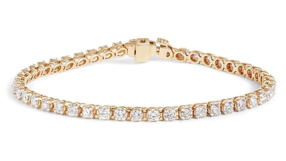 A gold tennis bracelet featuring a single row of round, clear gemstones set in individual prongs with a clasp closure—an elegant choice for meaningful gifts.
